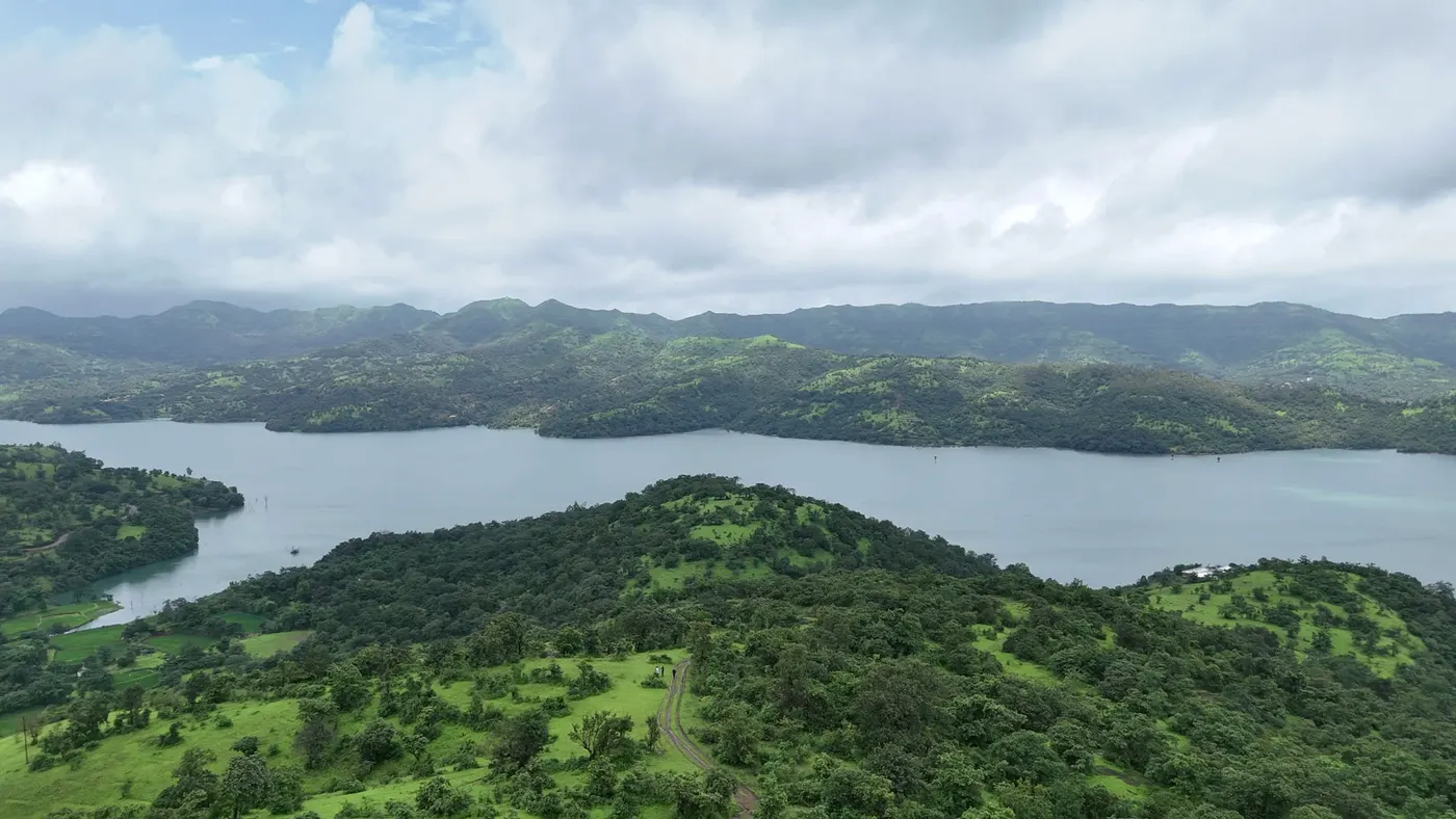 Wide backwaters between forested ridges under a cloudy sky