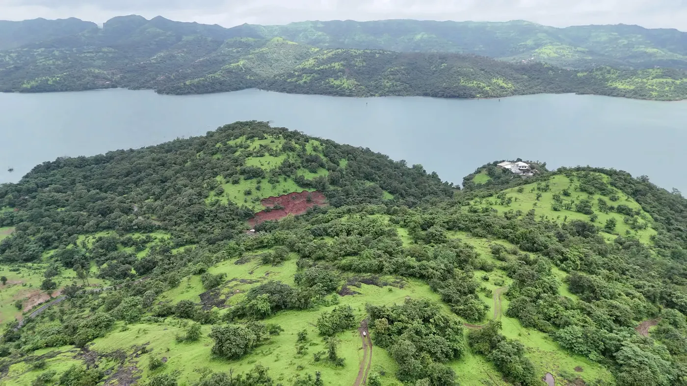Green, tree-dotted hilltops rising above the backwaters